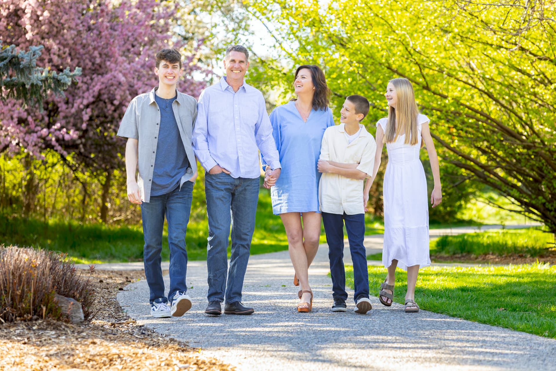 Family walking a spring path lined with blossoming trees