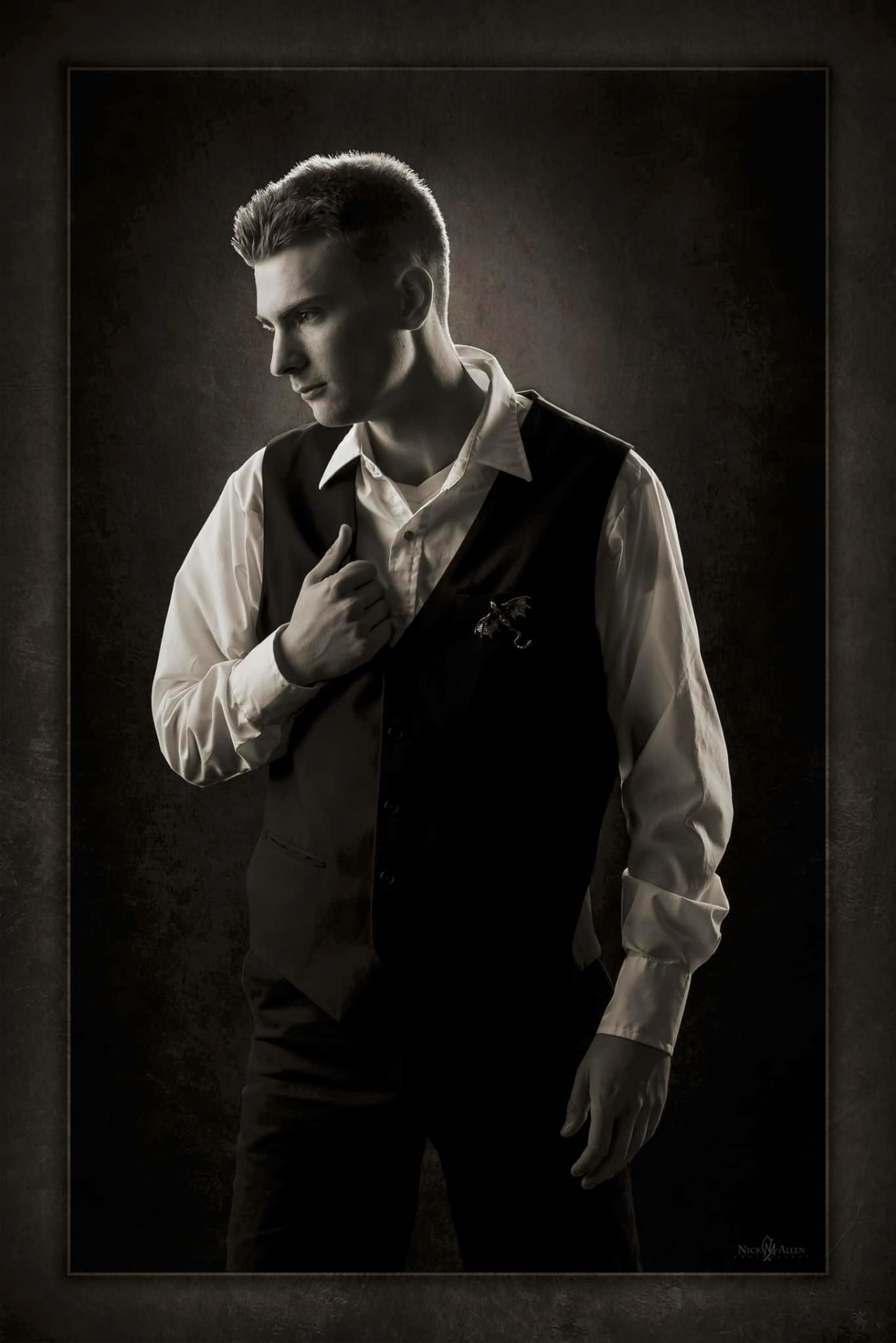 Black and white senior portrait of a young man in a vest